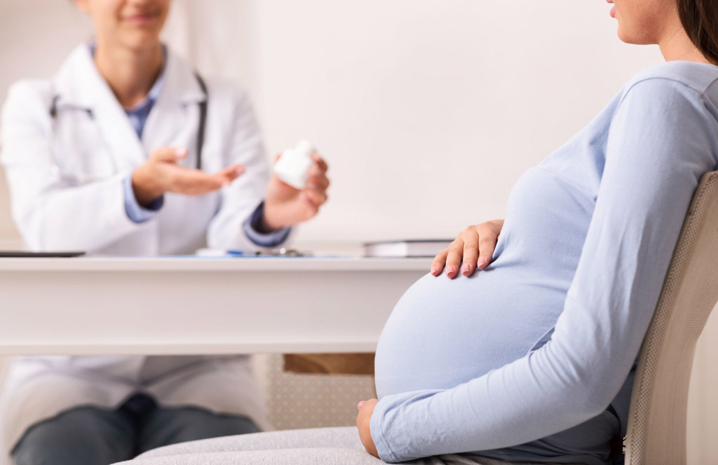 Pregnant woman talking to her doctor about safe solutions for heartburn during pregnancy
