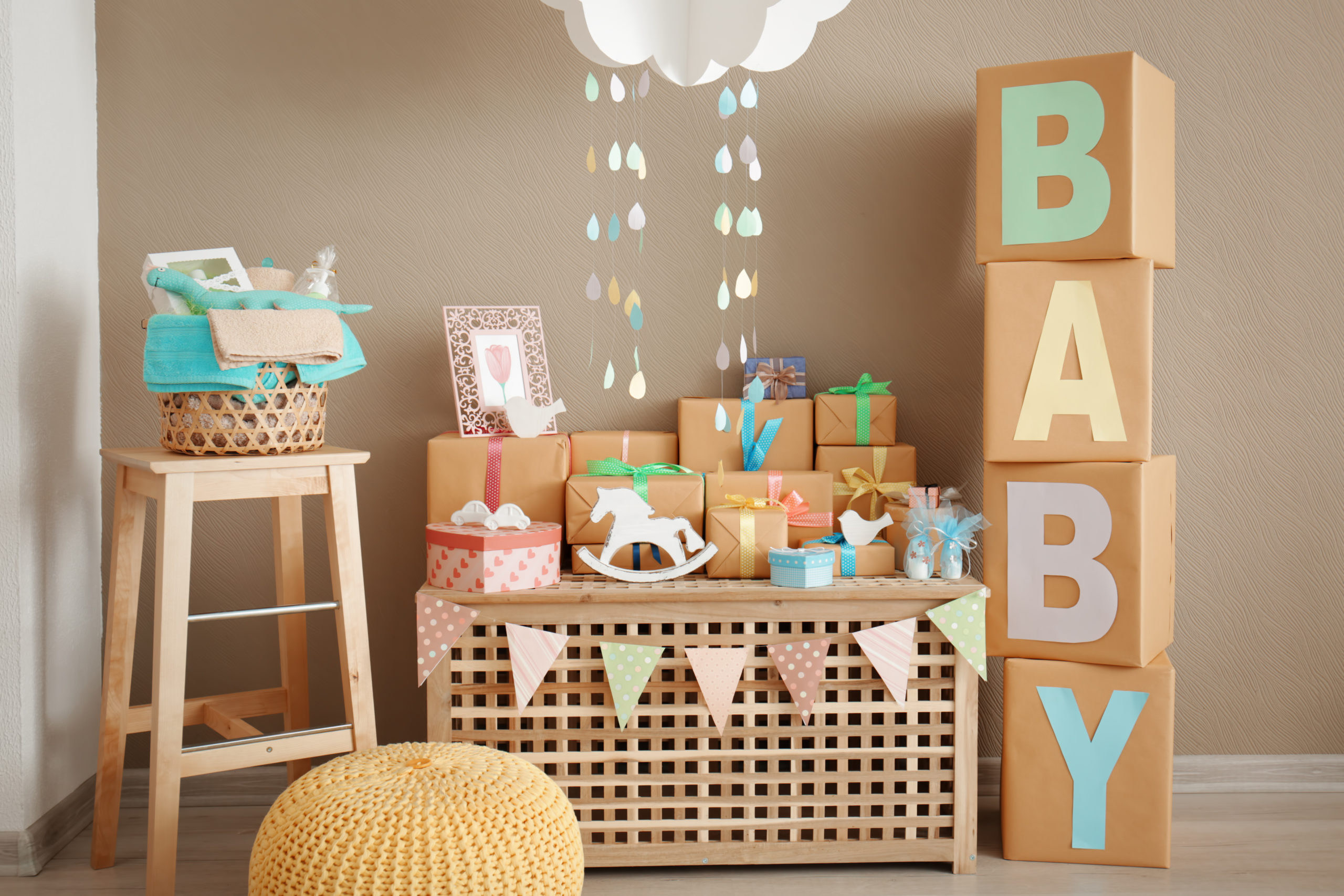 Baby shower decorations, gifts, and food options at indoor celebration.