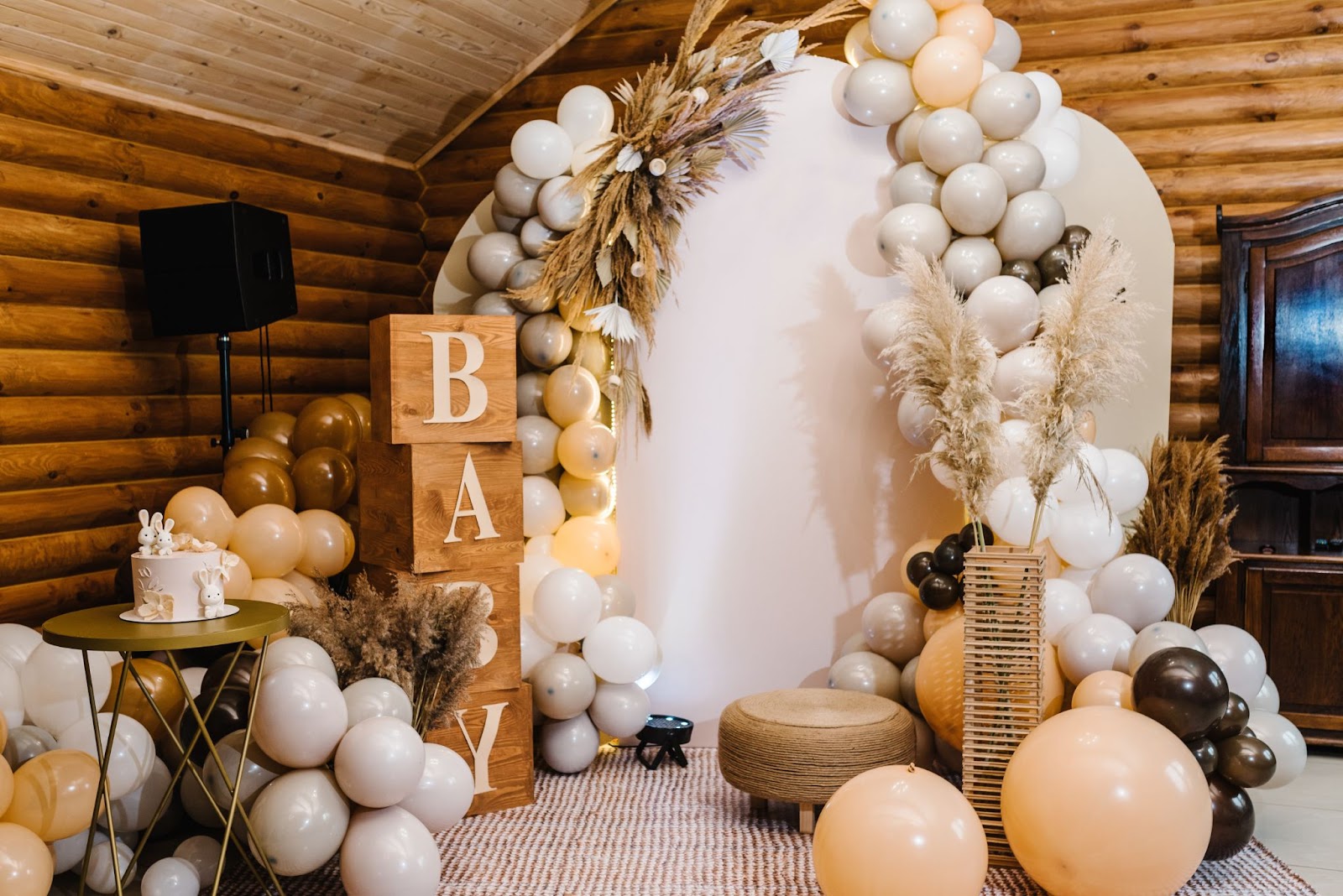 Beautiful luxury baby shower with balloons, garland and cake and stacked blocks that spell out BABY.